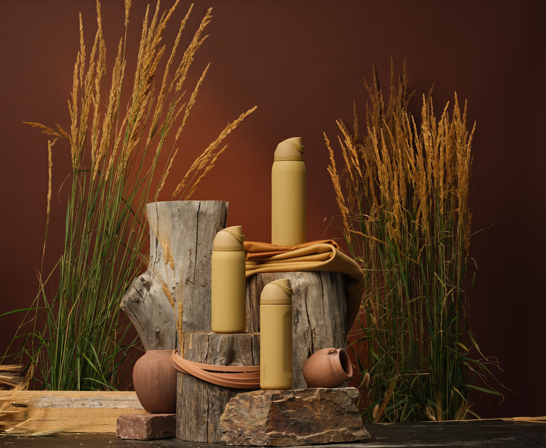 Autumn Vista FreeSip bottles displayed on logs with layered fall textures